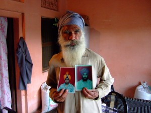 A man shows photos of his sons who were disappeared during the Indian government's counterinsurgency campaign in Punjab. 